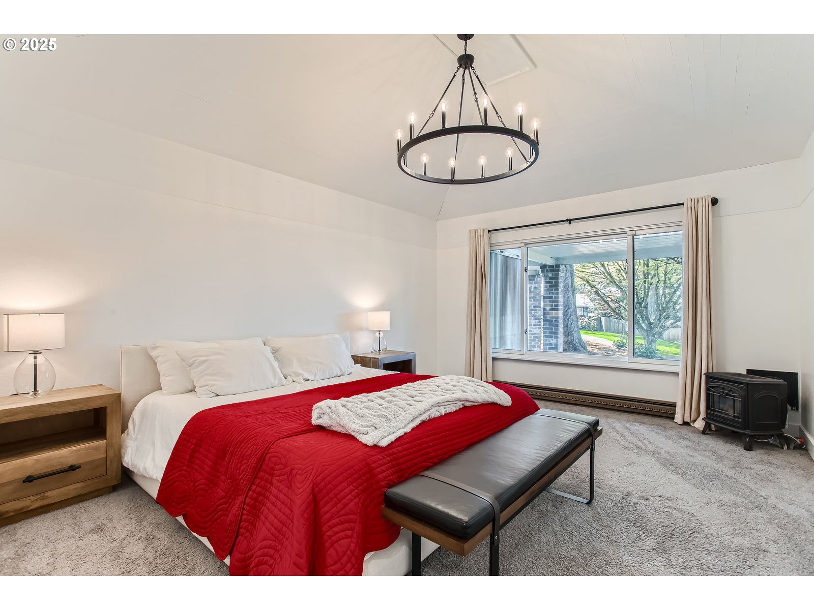 6121 Southwest Wilbard Street Portland, OR 97219 - Photo 14 of 28 a bedroom with a bed and a chandelier