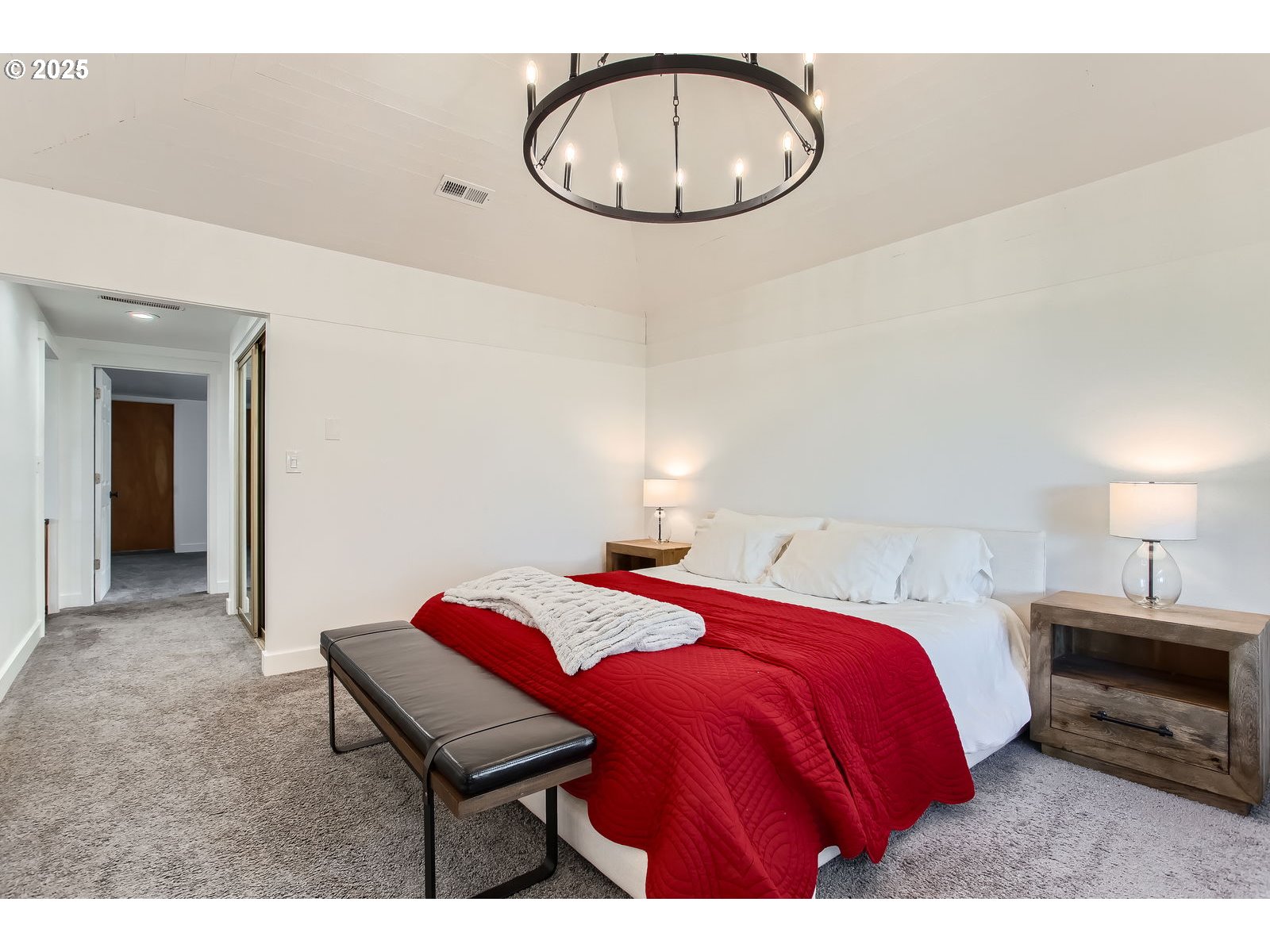 6121 Southwest Wilbard Street Portland, OR 97219 - Photo 15 of 28 a bedroom with a bed and a chandelier