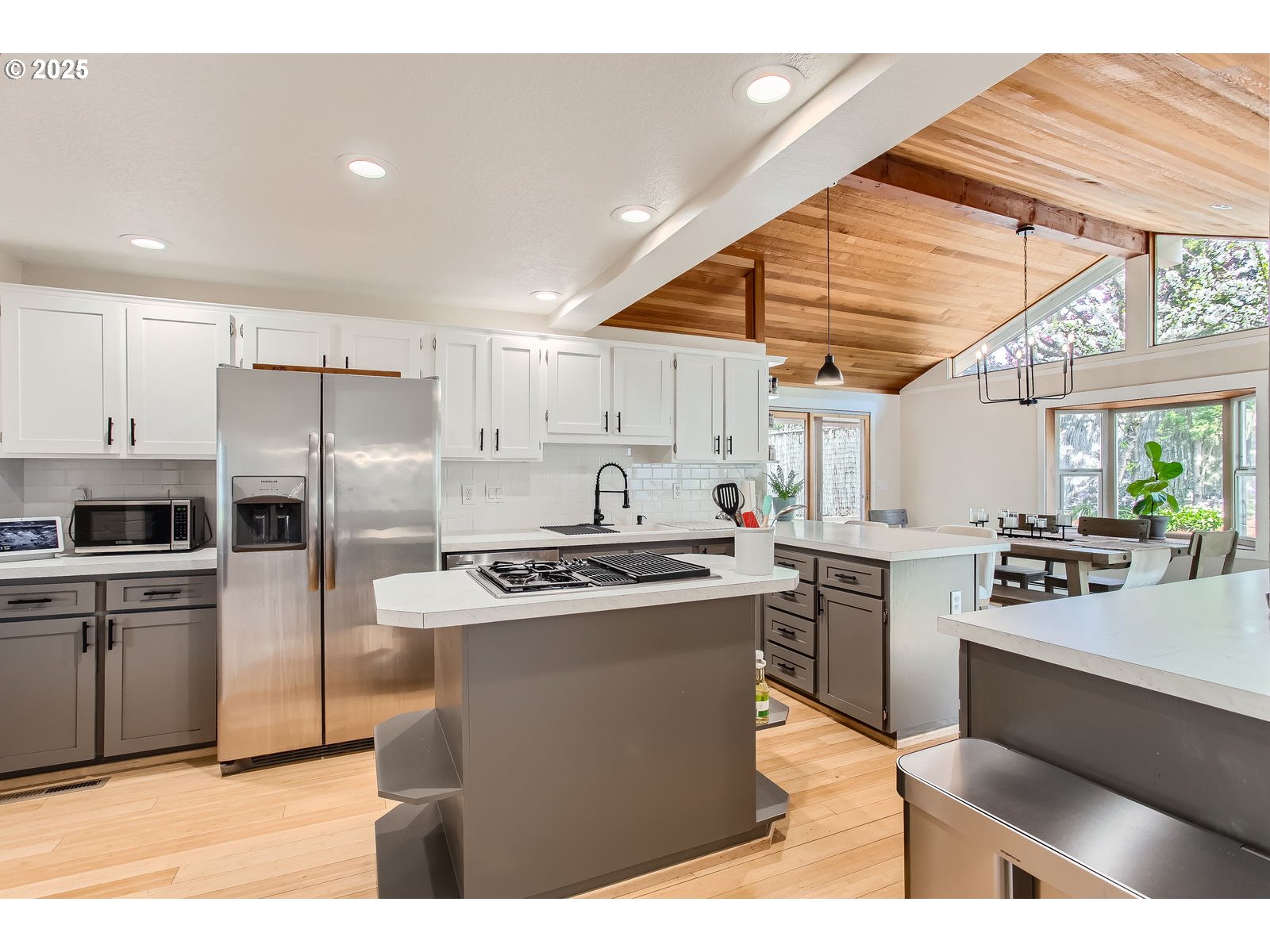 6121 Southwest Wilbard Street Portland, OR 97219 - Photo 9 of 28 a kitchen with stainless steel appliances granite countertop a stove a sink dishwasher a refrigerator and white cabinets with wooden floor