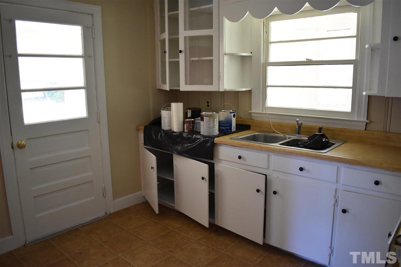 411 Pine Street Smithfield, NC 27577 - Photo 11 of 13 a kitchen with granite countertop white cabinets and window
