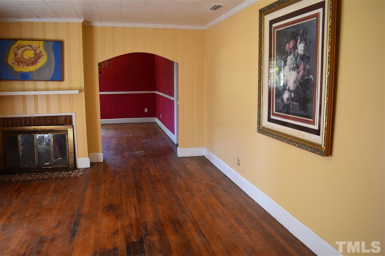 411 Pine Street Smithfield, NC 27577 - Photo 4 of 13 a view of an empty room with wooden floor and a fireplace