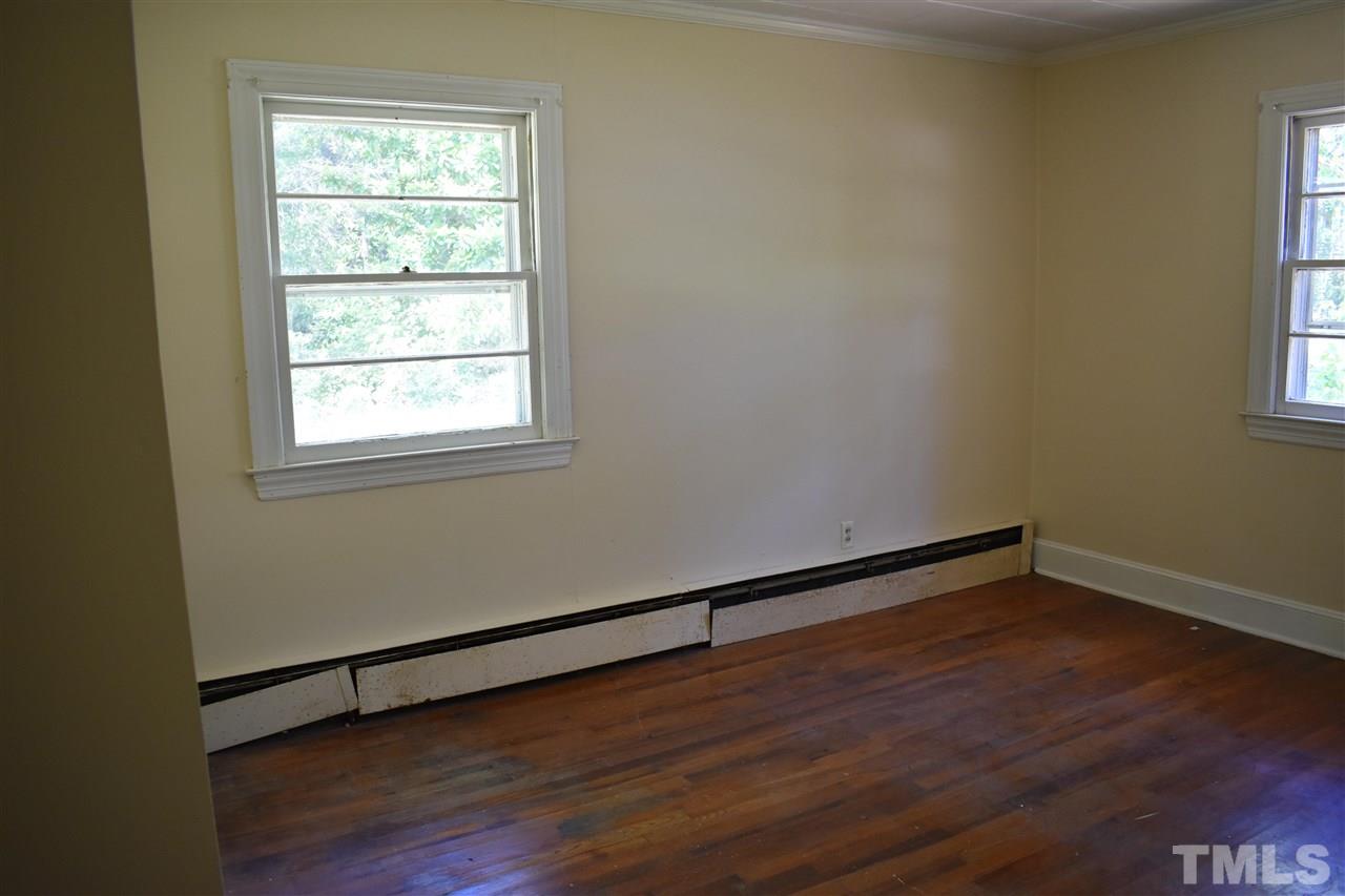 411 Pine Street Smithfield, NC 27577 - Photo 5 of 13 an empty room with wooden floor and windows