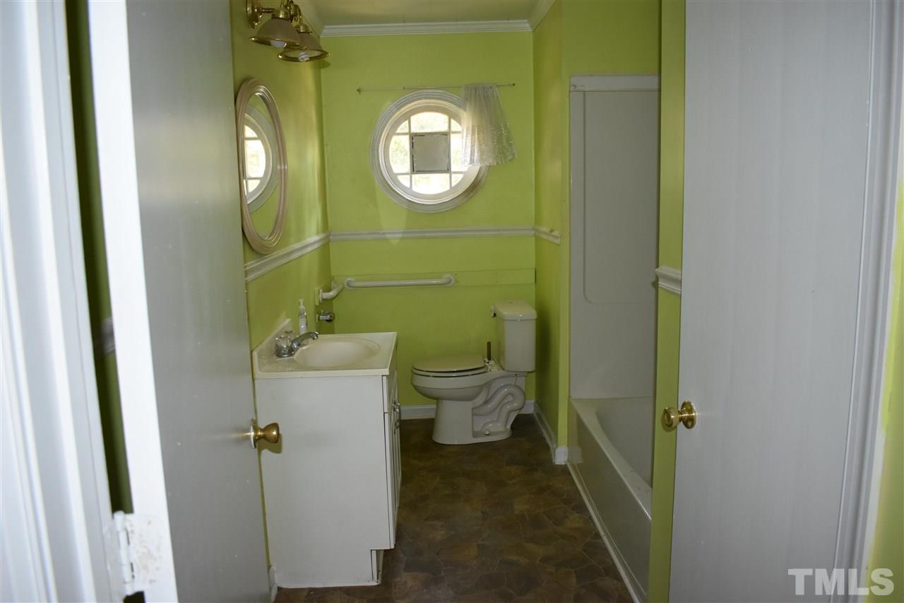 411 Pine Street Smithfield, NC 27577 - Photo 6 of 13 a bathroom with a sink and mirror with toilet