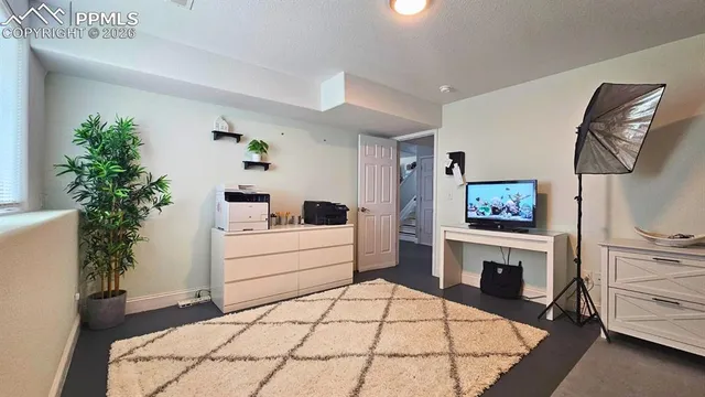 a view of a patio with table and chairs potted plants and floor to ceiling window