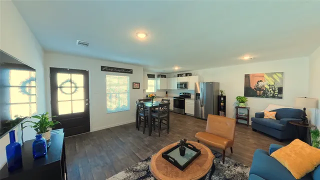 a living room with furniture and wooden floor