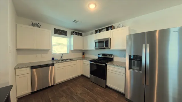 a kitchen with stainless steel appliances a refrigerator sink and microwave