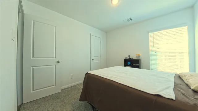 a bedroom with a bed and a window