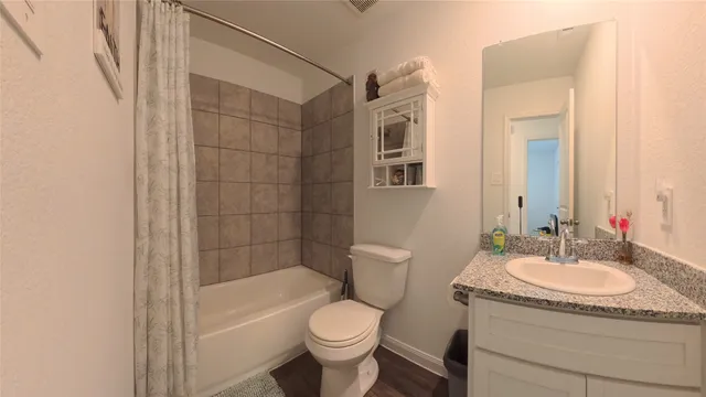 a bathroom with a granite countertop sink toilet and shower