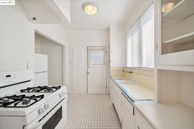 a kitchen with a refrigerator sink stove and cabinets