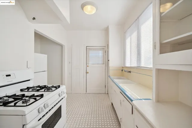 a kitchen with a refrigerator sink stove and cabinets