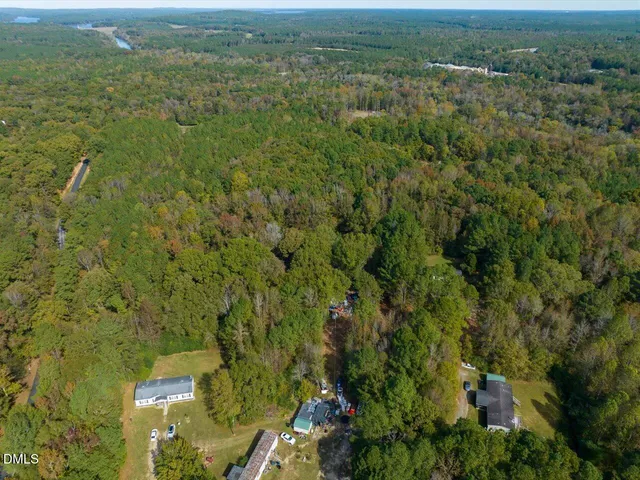 an aerial view of residential houses with outdoor space and trees