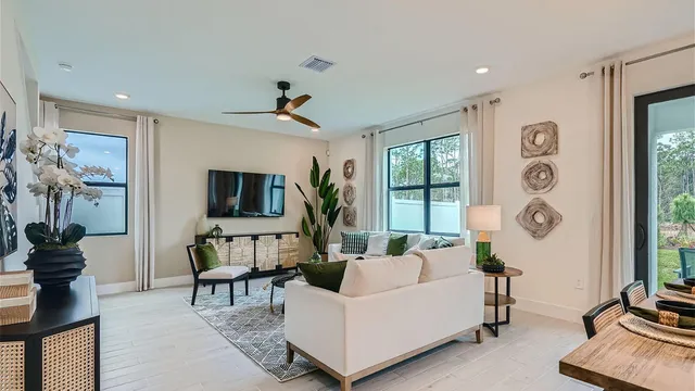 a living room with furniture a flat screen tv and a large window