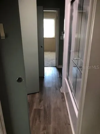 a view of a hallway with wooden floor and staircase