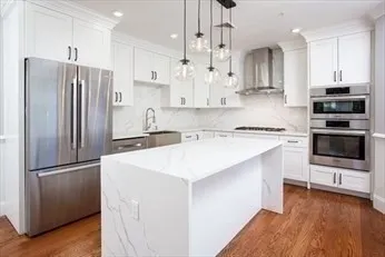 a kitchen with kitchen island a sink stainless steel appliances and cabinets