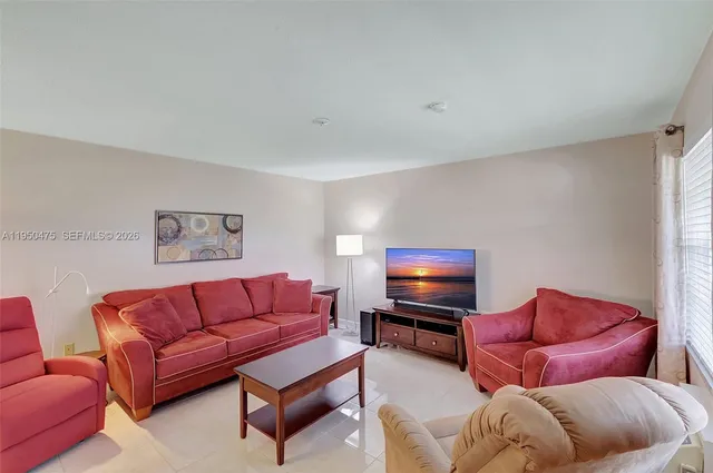a living room with furniture a flat screen tv and a window