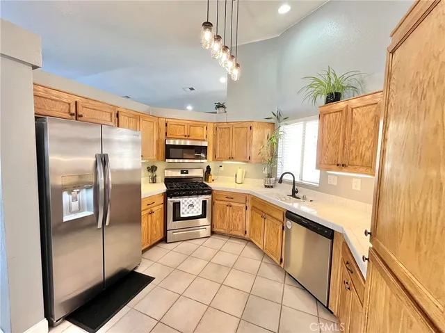 a large kitchen with granite countertop a large counter top stainless steel appliances a sink cabinets and stainless steel appliances