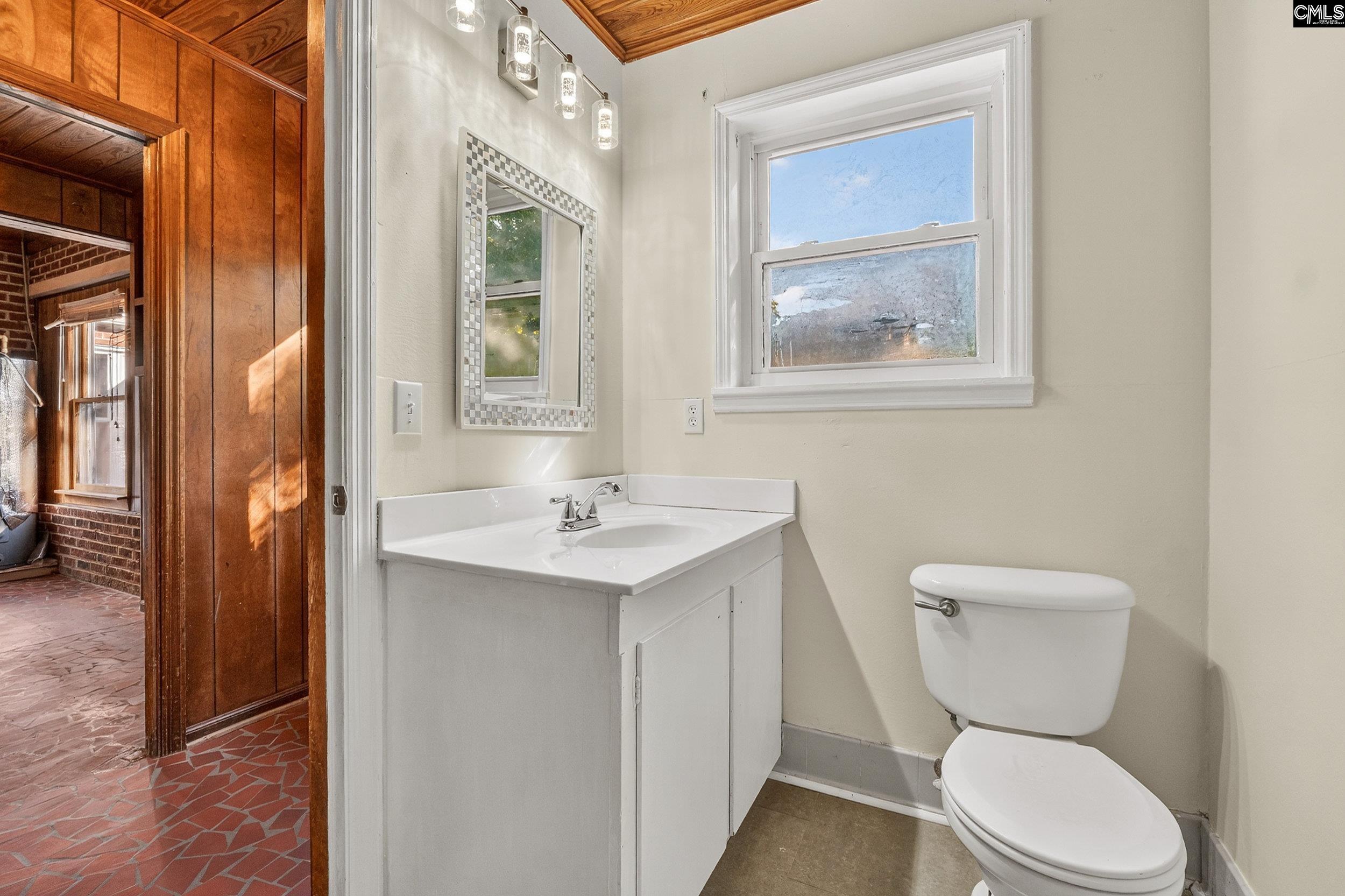 729 Magnolia Street Pelion, SC 29123 - Photo 22 of 32 a bathroom with a toilet a sink and a mirror
