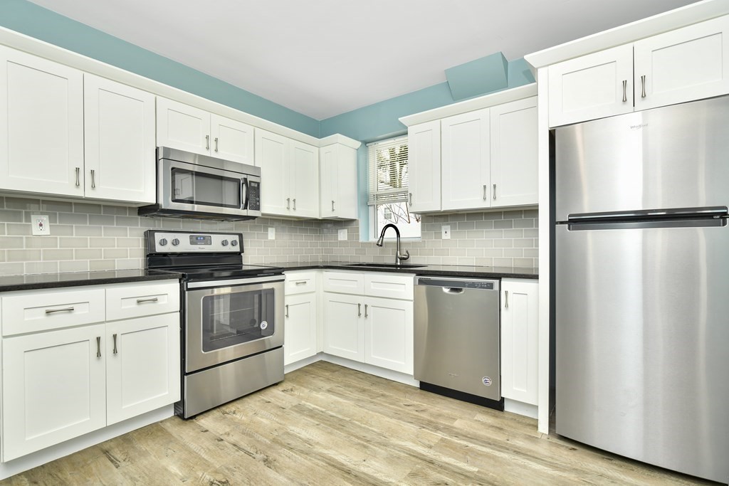 a kitchen with stainless steel appliances white cabinets white and a granite counter tops