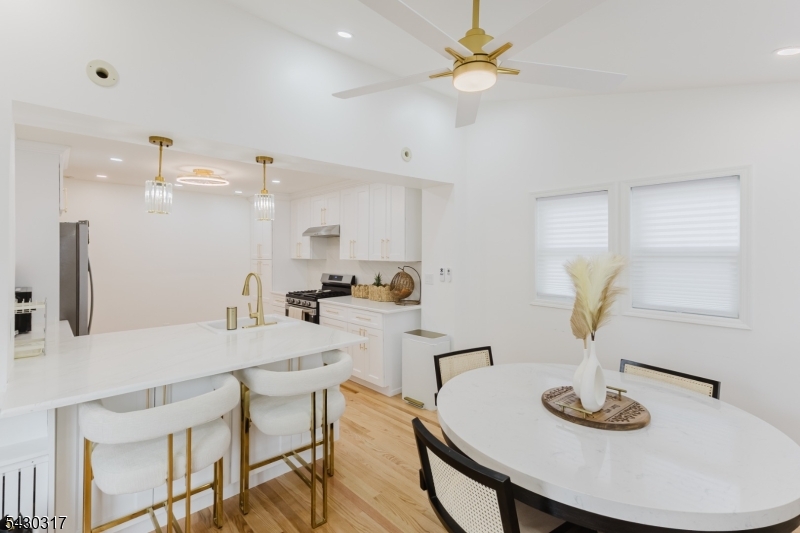 382 Martin Road Union, NJ 07083 - Photo 8 of 30 a kitchen with stainless steel appliances a table and chairs in it