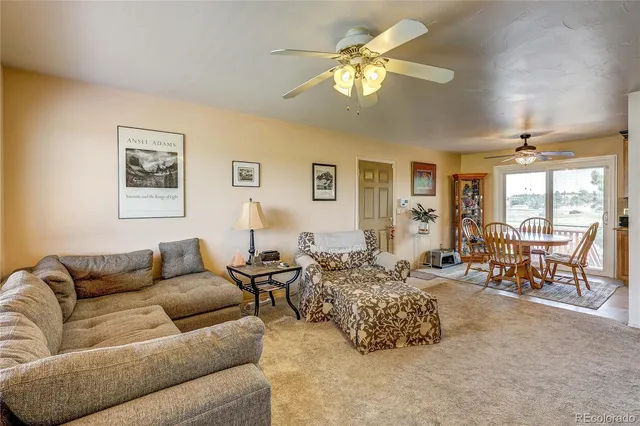 a living room with furniture chandelier and a view of kitchen