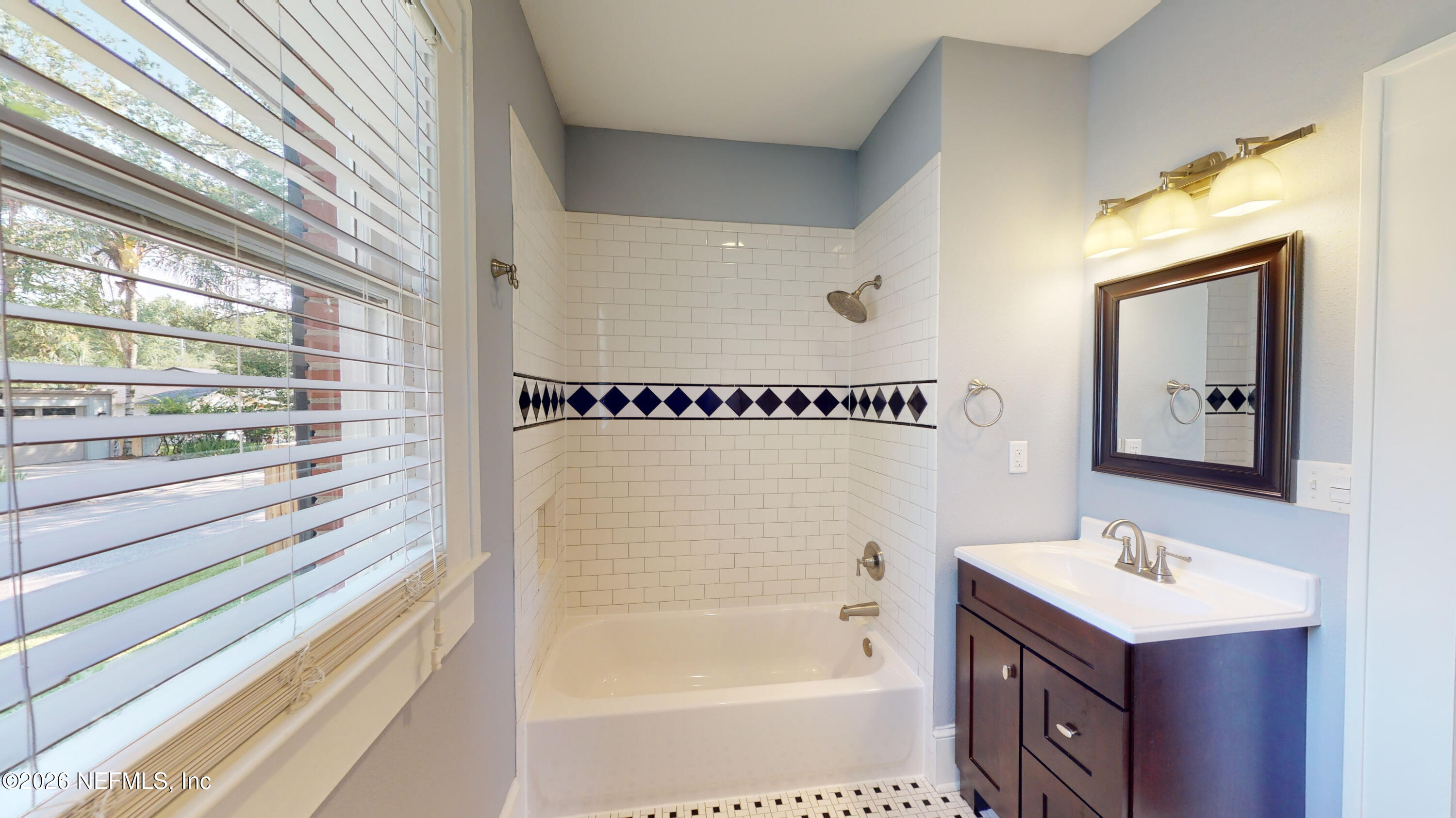 1292 Wolfe Street Jacksonville, FL 32205 - Photo 12 of 27 a bathroom with a sink a mirror and a bathtub
