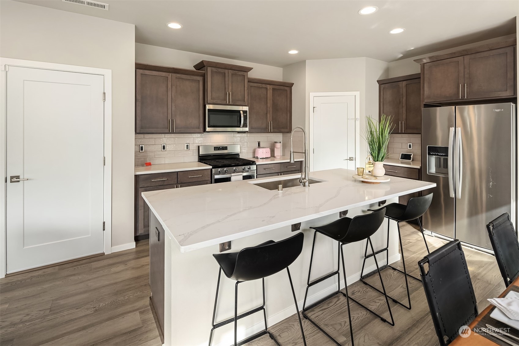 116 180th Place Southwest Bothell, WA 98012 - Photo 7 of 32 a kitchen with stainless steel appliances a stove a refrigerator a sink a dining table and chairs
