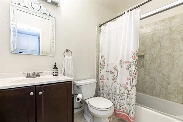 a bathroom with a sink toilet a mirror and shower