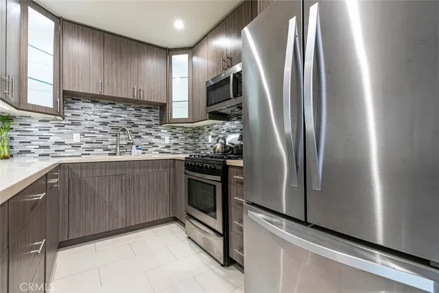 a kitchen with stainless steel appliances granite countertop wooden cabinets and a stove top oven