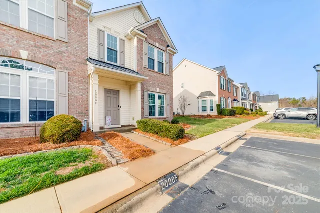 a view of a white house with a yard and plants