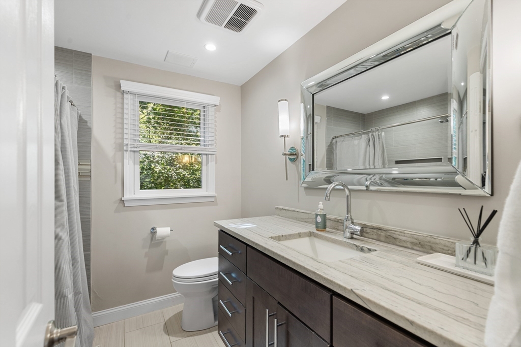 16 Cooke Road Lexington, MA 02420 - Photo 15 of 21 a bathroom with a granite countertop sink a toilet and a mirror