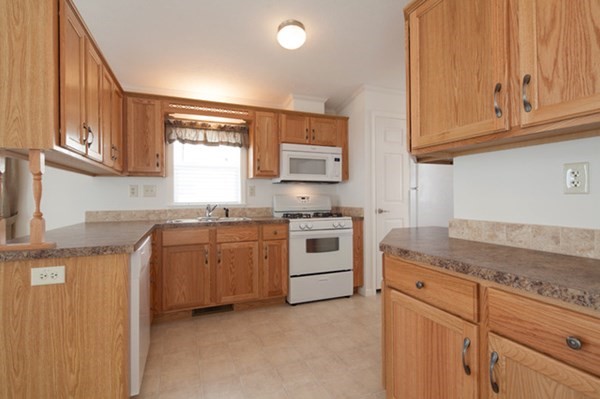 1044 Phillips Road, Unit 12 New Bedford, MA 02745 - Photo 5 of 9 a kitchen with granite countertop cabinets stainless steel appliances and a sink
