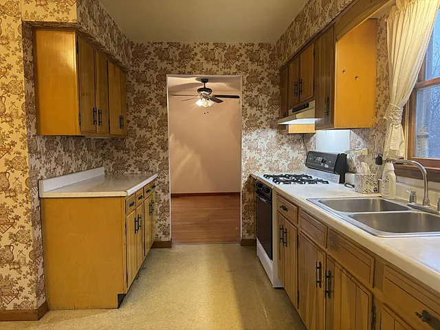 a kitchen with stainless steel appliances granite countertop a sink and a stove