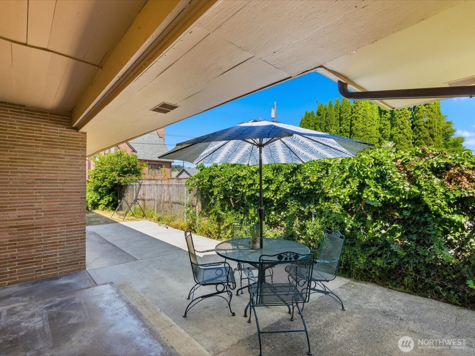 1417 Maple Street Sumner, WA 98390 - Photo 40 of 40 a view of patio with chairs and table under an umbrella