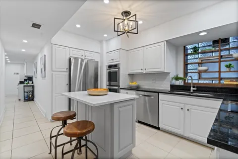 a kitchen with stainless steel appliances a sink a stove and cabinets