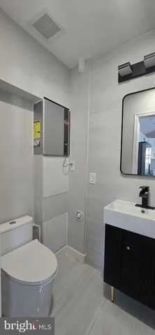 a bathroom with a toilet a sink and mirror