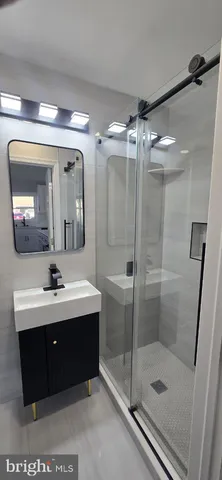 a bathroom with a sink mirror and a shower