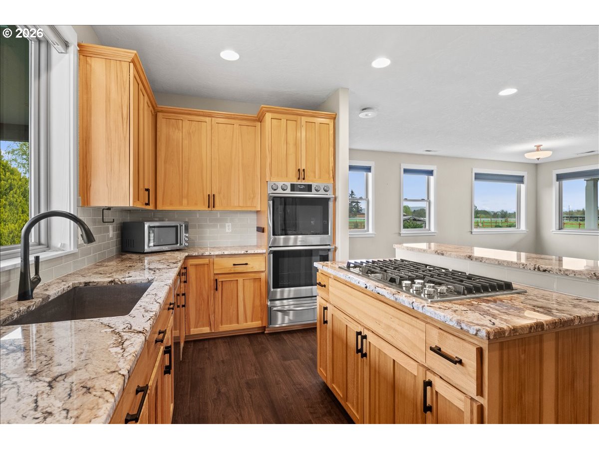 9864 Hoffman Road Monmouth, OR 97361 - Photo 20 of 48 a kitchen with stainless steel appliances granite countertop a stove a sink dishwasher and cabinets with wooden floor