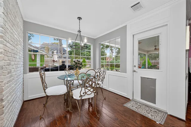 a dining room with furniture a chandelier and wooden floor