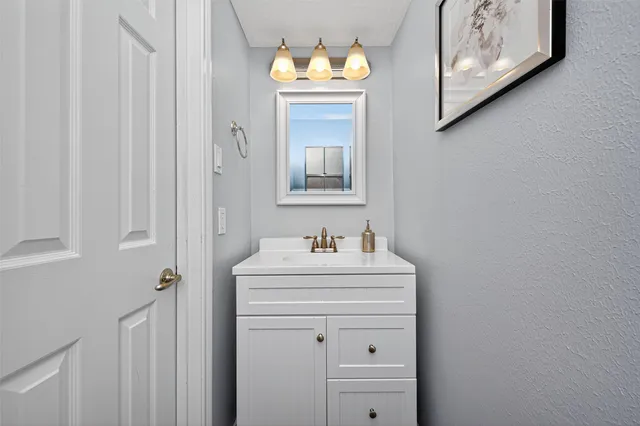 a bathroom with a sink mirror and vanity