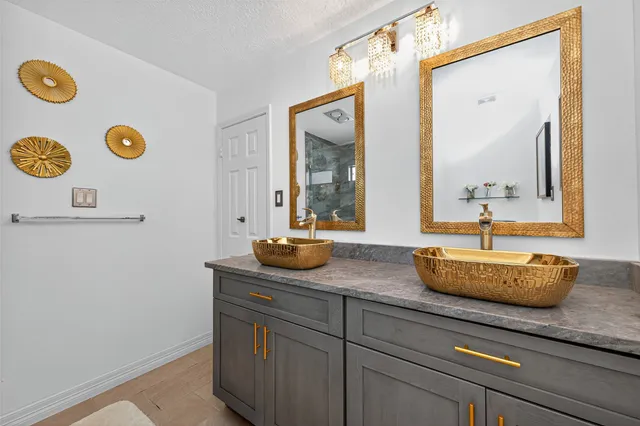 a bathroom with a granite countertop sink and a mirror