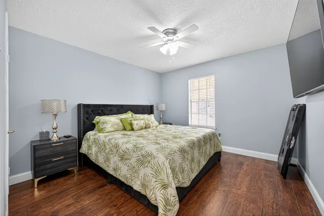 a bedroom with a bed and a flat tv screen on dresser
