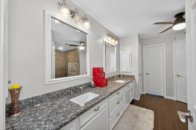 a bathroom with a granite countertop sink and a mirror