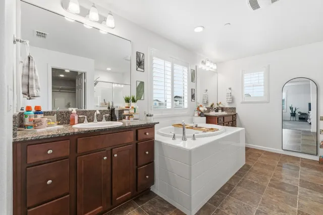 a spacious bathroom with a sink double vanity and a mirror