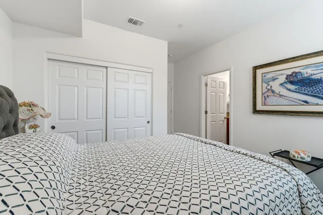 a bedroom with a bed and a painting on the wall