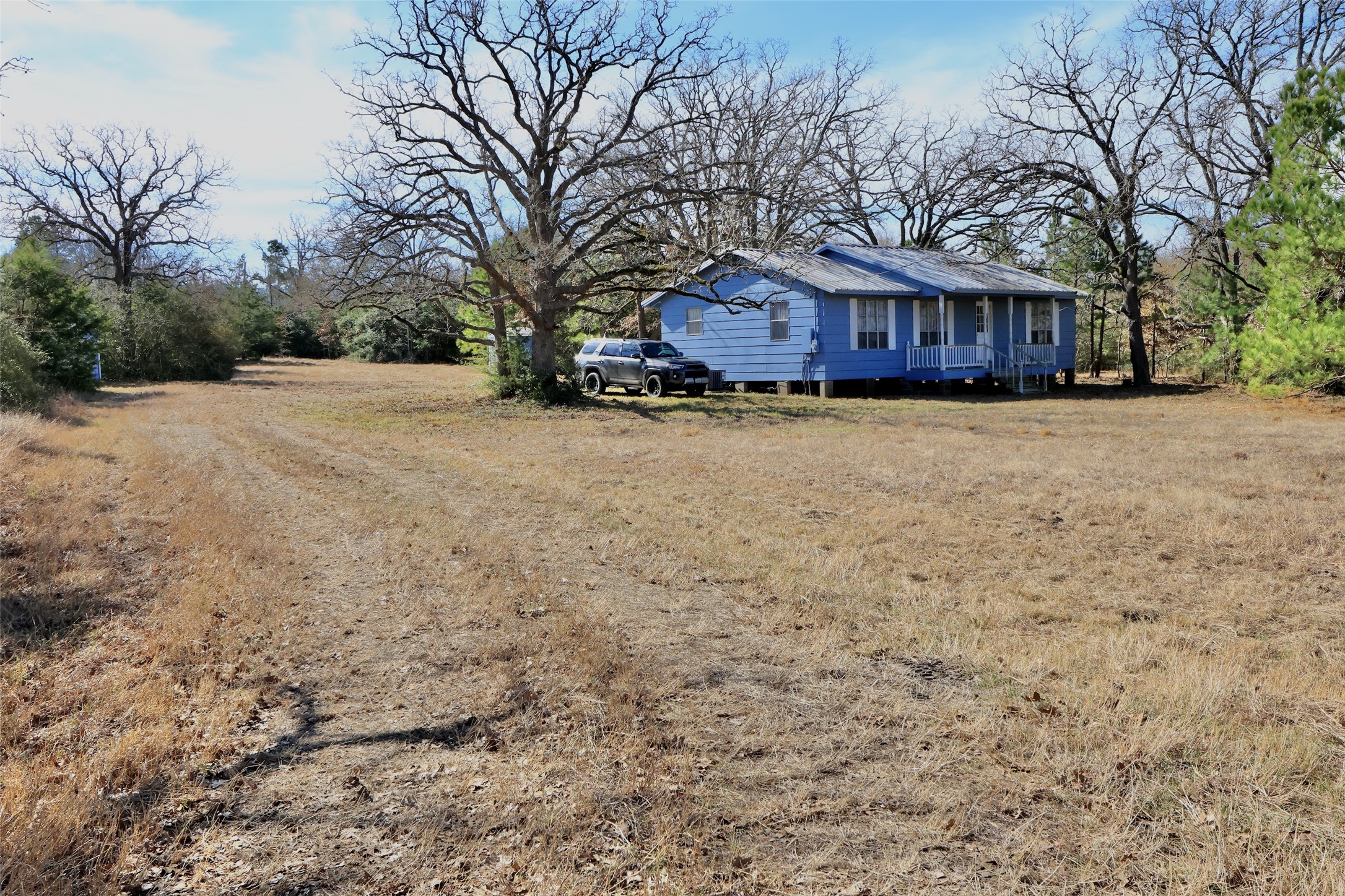 10173 Deer Ridge Road Bedias, TX 77831 - Photo 22 of 46 a wooden bench sitting in front of a house