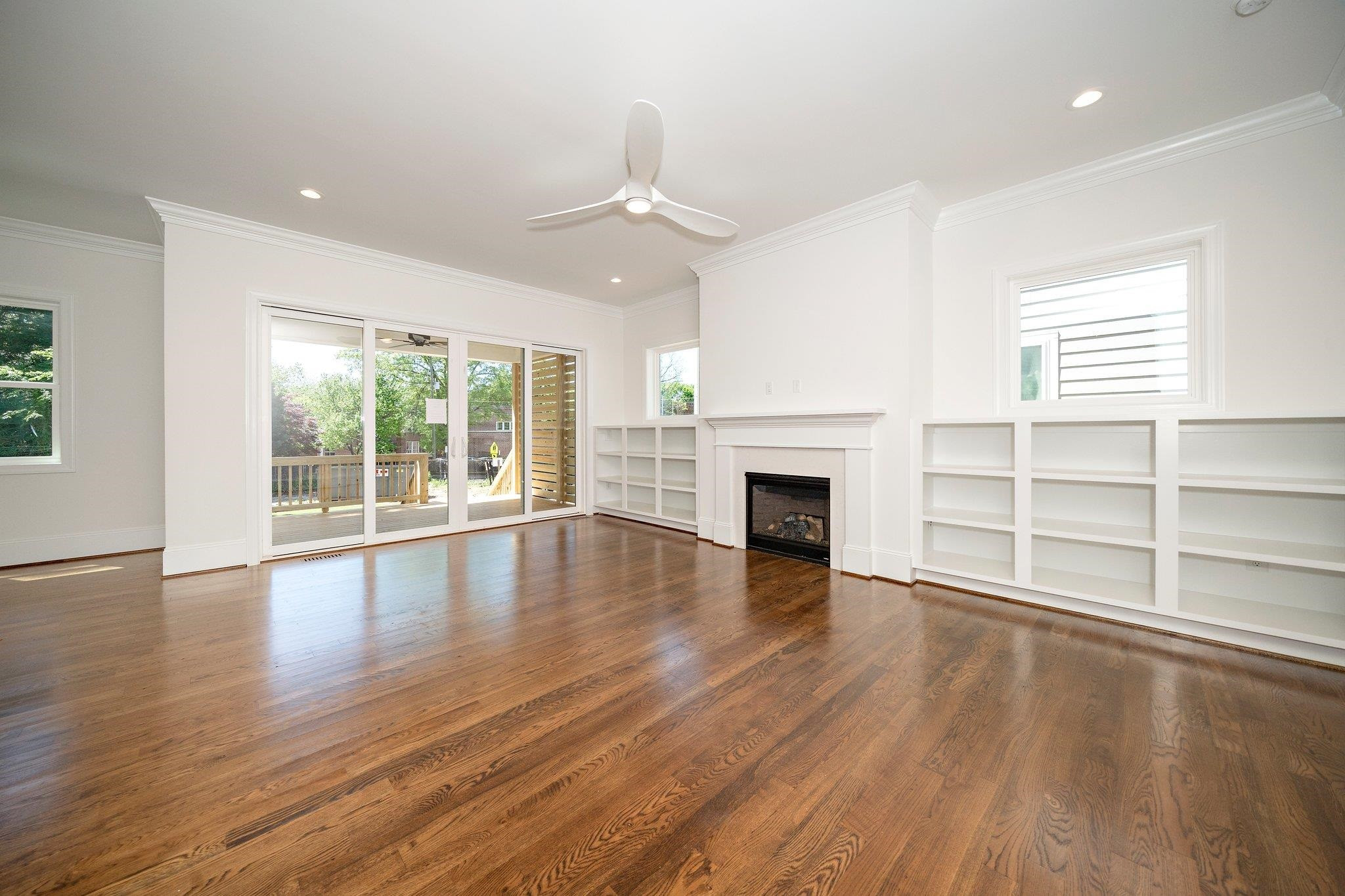 1809 Fairview Road Raleigh, NC 27608 - Photo 15 of 37 an empty room with wooden floor fireplace and windows