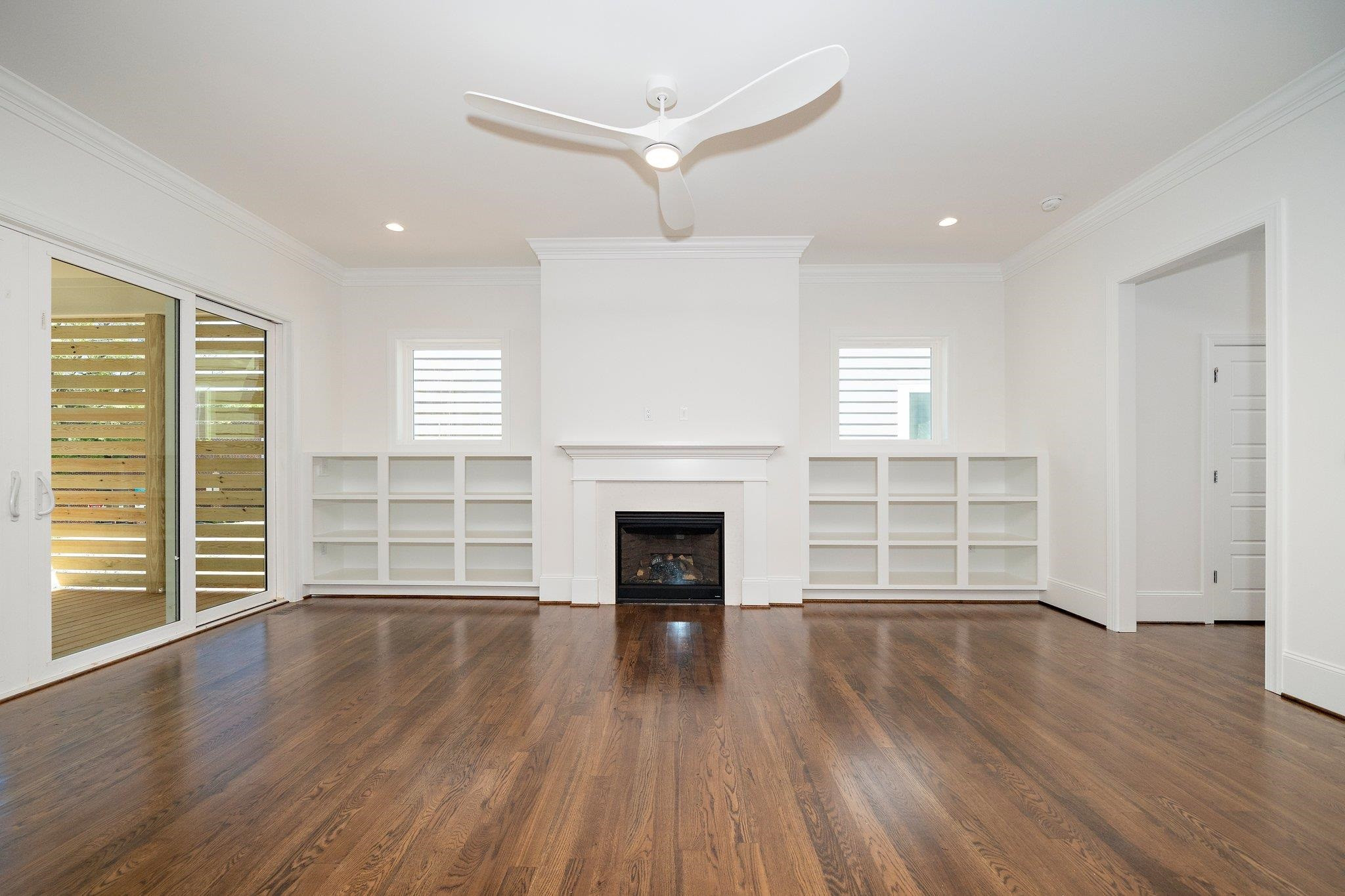 1809 Fairview Road Raleigh, NC 27608 - Photo 16 of 37 an empty room with wooden floor fireplace and windows