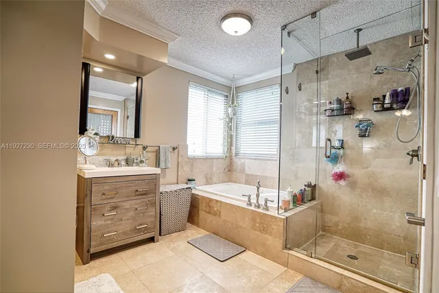 a bathroom with a tub sink mirror and shower