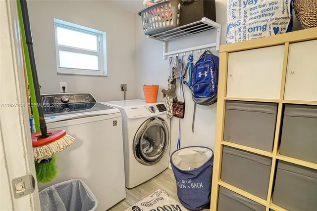 a utility room with fridge dryer and washer