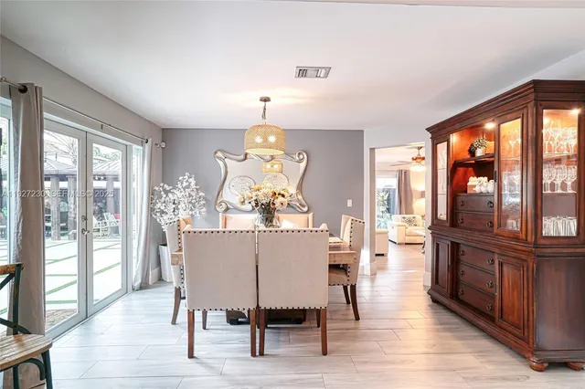 a dining room with furniture a chandelier and wooden floor